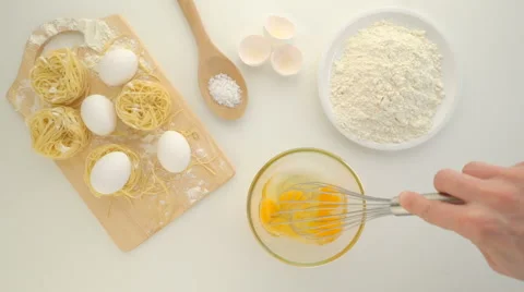 Cooking with eggs, raw eggs in a dish and flour on a table. Stock Footage 62065904