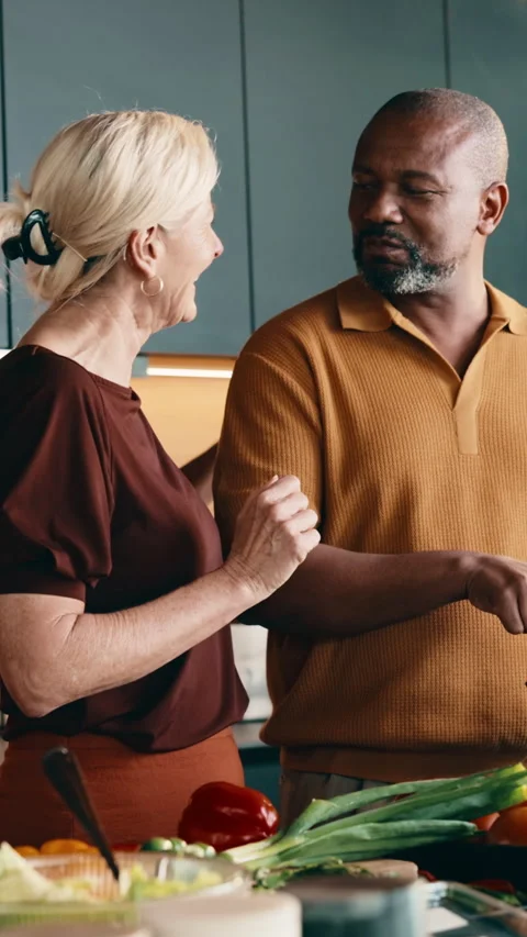 Cooking, feed and smile of interracial couple in kitchen together for diet or Stock Footage 338011244