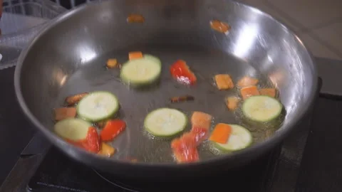 Cooking on fire. The chef cooks vegetables and meat in a pan with the fire Stock Footage 98071731