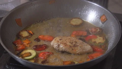 Cooking on fire. The chef cooks vegetables and meat in a pan with the fire Stock Footage 98072021