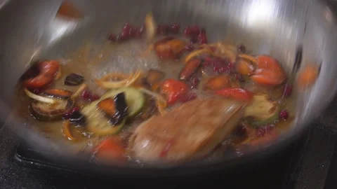 Cooking on fire. The chef cooks vegetables and meat in a pan with the fire Stock Footage 98072097