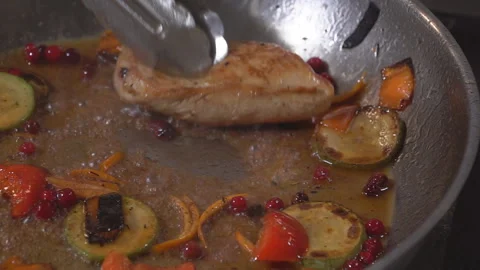 Cooking on fire. The chef cooks vegetables and meat in a pan with the fire Stock Footage 98072255