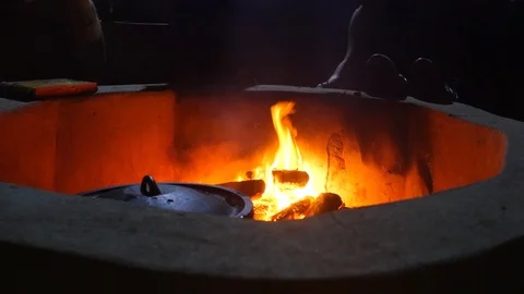 A cooking fire with pot in foreground set in a stone circle. Stock Footage 95006285