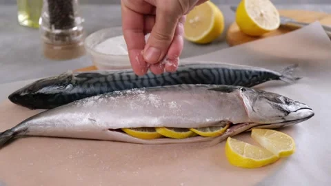 Cooking fish. The chef sprinkles the raw fresh fish with salt. Stock Footage 148160444