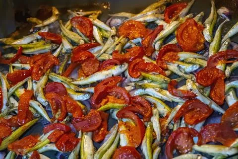 Cooking fish with cherry tomatoes and herbs on parchment in the oven Stock Photos