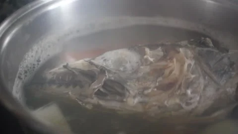 Cooking fish head with vegetables in boiling water for stock Stock Footage 345749351