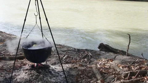 Cooking fish soup in a cauldron on a fire in nature near the autumn river 스톡 동영상 257045782