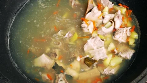 Cooking fish soup in a large pot, outdoors in field conditions. Fishing food. Stock Footage 155395593