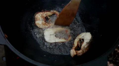 Cooking fish. Three pieces of fish frying in boiling sunflower oil in a cauldron Stock Footage 63757888
