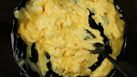 Cooking fluffy scramble eggs for breakfast. Scrambled eggs, omelette Stockbeeldmateriaal 236288319