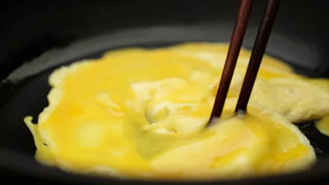 Cooking fluffy scrambled eggs close up Stock Footage 203874060