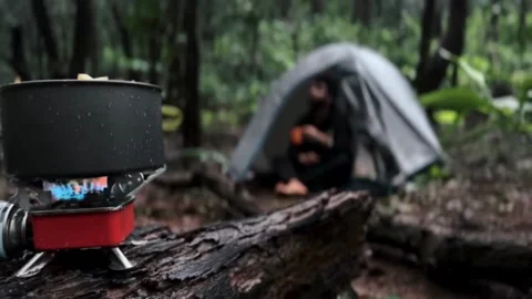Cooking in forest, A boy camping in forest and drinking tea. Stock Footage 285928437
