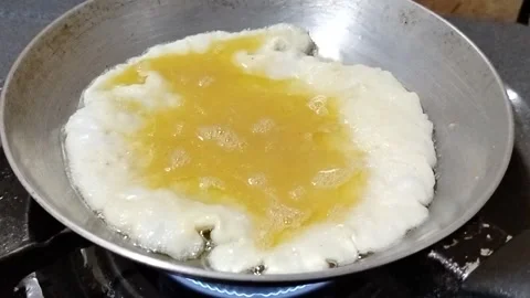 Cooking a fresh chicken egg in a teflon frying pan with hot oil for a homemade  Stock Footage 338224859