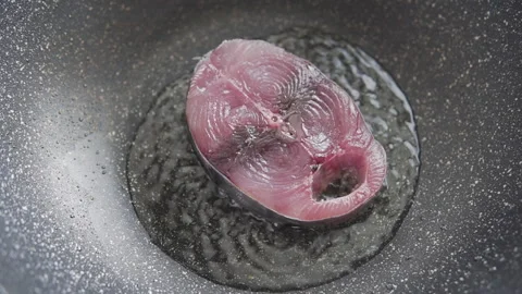 Cooking fresh piece of small tuna fish in a wok Stock Footage 260367752
