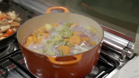Cooking fresh sweets potato, beans and onion in orange pot on gas stove Video stock 220767973