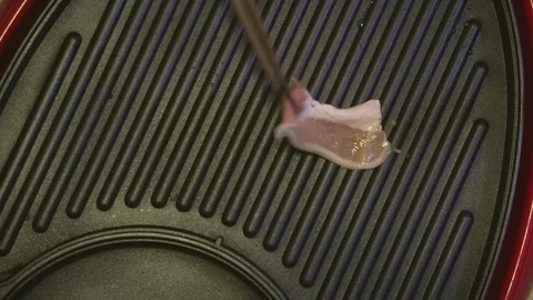 Cooking fried bacon pork on Teflon frying pan Stock Footage 83704652