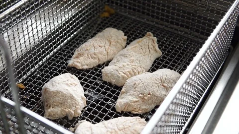 Cooking fried breaded chicken. Close up of Frying chicken nuggets in the fryer Video stock 107673931