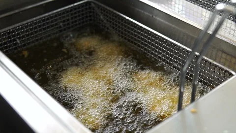 Cooking fried breaded chicken. Close up of Frying chicken nuggets in the fryer Video stock 107674234