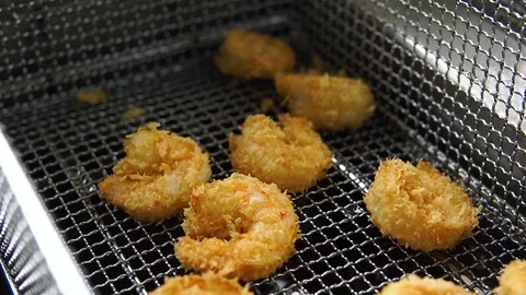Cooking fried breaded shrimp. Close up of Frying crispy shrimp in the fryer in Stock Footage 107675424