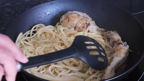 Cooking fried chicken legs with spaghetti. Pan with glass lid. Stock Footage 135411927