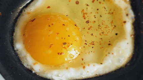 Cooking a fried egg from one egg in a mini pan Stock Footage 101727458