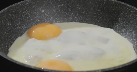 Cooking fried eggs for breakfast. Close-up, slow motion shot Stock Footage 249992427