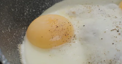Cooking fried eggs on a frying pan. Close-up, slow motion shot Stock Footage 250795709