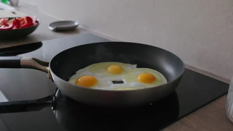 Cooking Fried Eggs in a Pan on Induction Stove Stock Footage 345834736