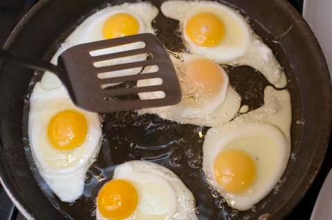 Cooking fried eggs Stock Photos