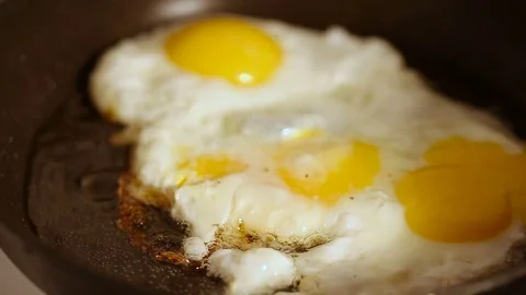 Cooking fried eggs with spice in frying pan for breakfast Video stock 72216209