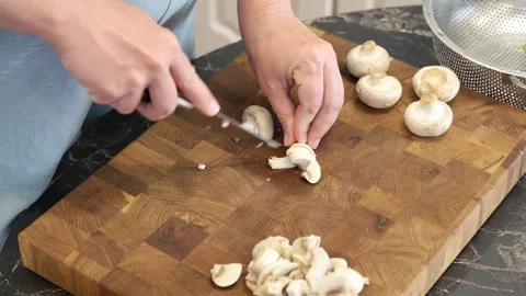 Cooking fried eggs with vegetables at home. A woman chops vegetables on a wooden Stock Footage 317543262