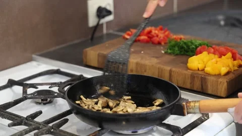 Cooking fried eggs with vegetables at home. A girl fries fried eggs with vegetab Stock Footage 317543759
