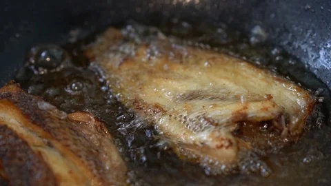 Cooking Fried Fish by Deep Frying with Hot Oil in Pan in Slow Motion Stock Footage 93540238