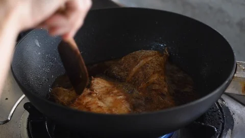 Cooking fried grouper fish on a hot black pan Stock Footage 101639616