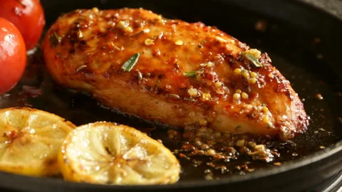 Cooking fried roasted chicken breasts lemon tomato rosemary mustard seeds honey Stock Footage 88973919
