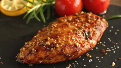 Cooking fried roasted chicken breasts cut knife lemon tomato mustard seeds honey Stock Footage 89148125