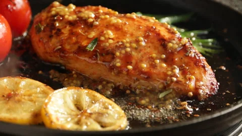 Cooking fried roasted chicken breasts with lemon tomato and rosemary close-up Stock Footage 89180326