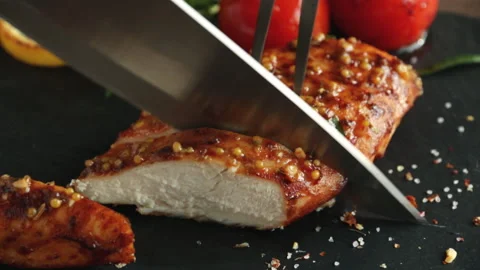 Cooking fried roasted chicken breasts cut knife with  tomato mustard seeds honey Stock Footage 89183973