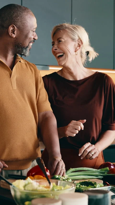 Cooking, funny and high five with interracial couple in kitchen together for Stock Footage 338019098