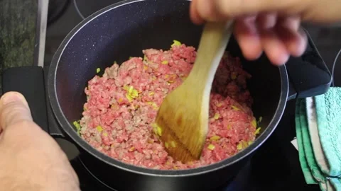 Cooking ground beef with vegetables in a kitchen at home for a delicious meal Stock Footage 294630648
