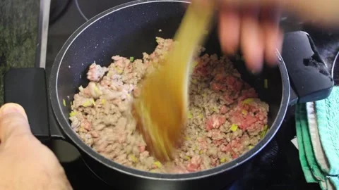 Cooking ground meat with vegetables in a kitchen stove pan Stock Footage 294630942