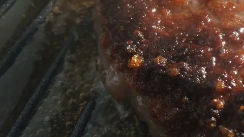 Cooking hamburger. Beef or pork cutlet grilling on grid. Slow motion. HD Stock Footage 115773549