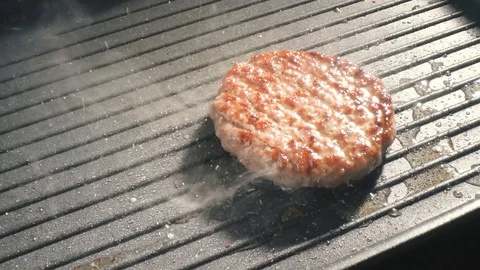 Cooking hamburger. Beef or pork cutlet grilling on grid. Slow motion. HD Stock-Footage 115774055