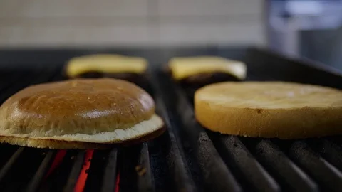 Cooking a hamburger burger, in the kitchen a cook is on fire Stock Footage 128116604