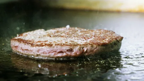 Cooking hamburger. Close-up of beef or pork cutlet grilled on grid for burger 4K Stock-Footage 98028172