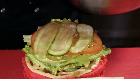 Cooking hamburger. Cook preparing burger with cutlet, smoked bacon, shrimps. 4K Stock-Footage 98113025