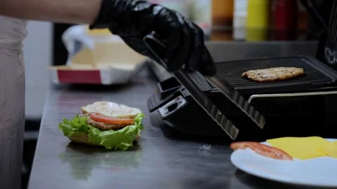 Cooking hamburger in the kitchen. Cooking a delicious burger. The chef puts Stock Footage 253315462