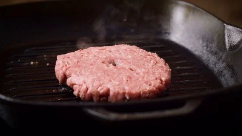 Cooking hamburger. One beef cutlet for burger is being fried in a grill pan. 4K 库存影片 79848199