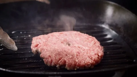 Cooking hamburger. One beef rissole for burger is being fried in broiler pan. 4K Stock Footage 82359058