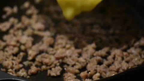 Cooking handheld close up adding eggs to sausage Stock Footage 93969855